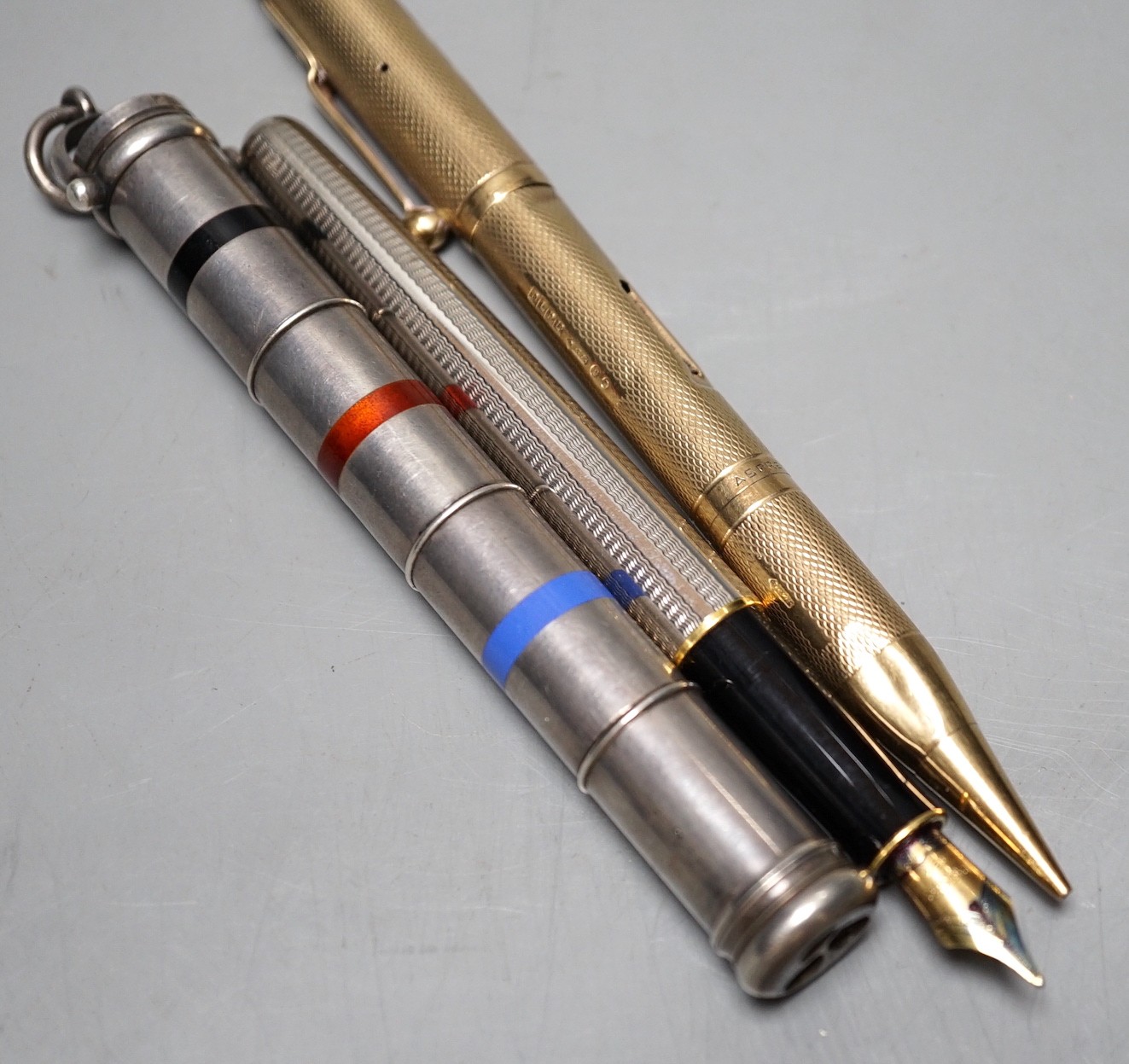 A 9ct yellow gold double ended Asprey pencil and fountain pen, a multi-colour propelling pen and one other (3)